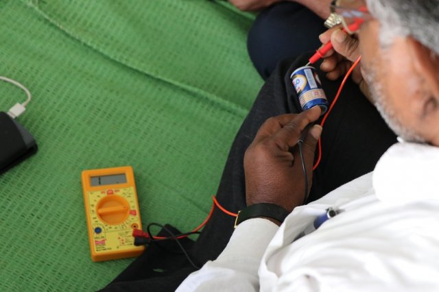 A teacher checking the resistance of battery.